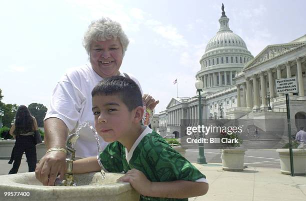 Delia Guerra helps her grandson Rene Guerra with a water fountain on the east side of the Capitol Thursday afternoon as tourists braved the hot sun...