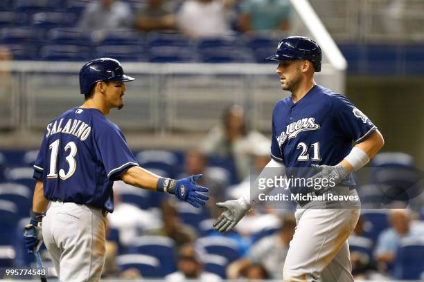 Travis Shaw of the Milwaukee Brewers celebrates with Tyler Saladino after hitting a solo home run in the eighth inning against the Miami Marlins at...
