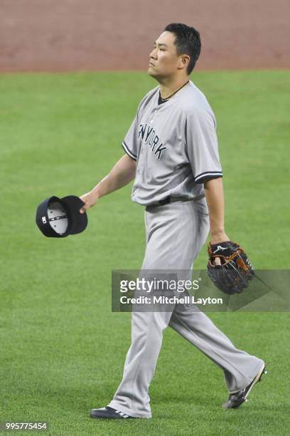 Masahiro Tanaka of the New York Yankees walks back to the dug out in the fifth inning during a baseball game against the Baltimore Orioles at Oriole...