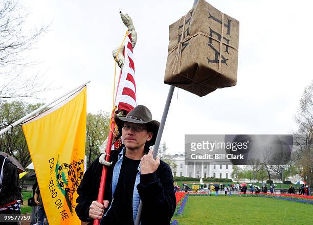 Ed Walsh, of Fairfax Station, VA, carries a mock box of tea on a pole in front of the White House during the national Tax Day Tea Party on Wednesday,...