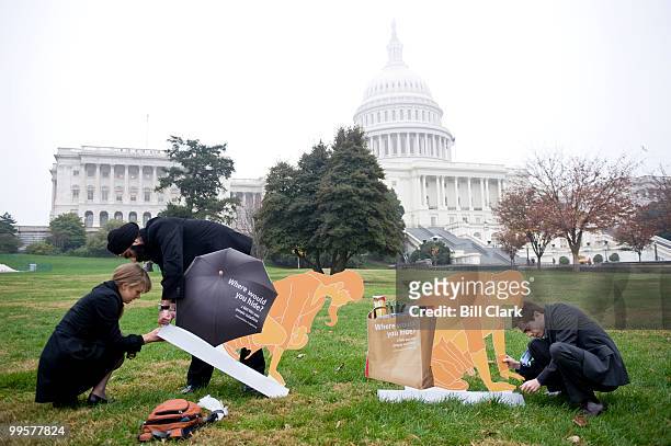 From left, Katryn Bowe, Ari Singh and Chris Hall, all of CSIS set up toilet displays on Thursday, Nov. 19 on the West Lawn of the Capitol in...
