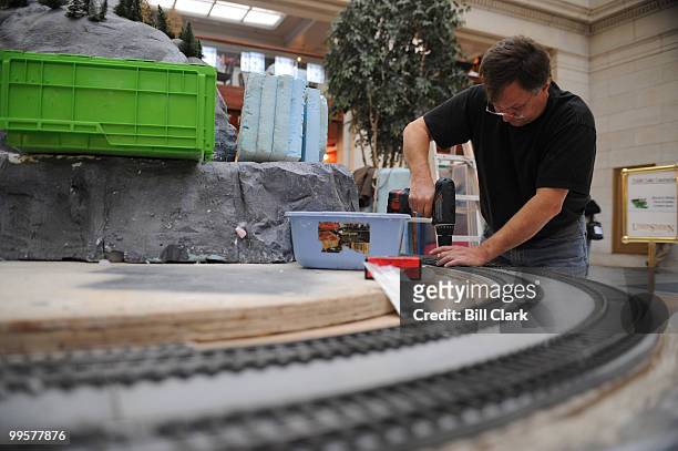 Model train builder Styrkar Baathen installs train tracks as work begins on the Norwegian model train exhibit in Union Station on Monday, Nov. 12,...