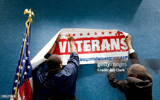 National Press Club staff hangs the Iraq Veterans for Congress banner behind the podium before the start of the group's news conference at the...