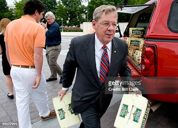 Sen. Johnny Isakson, R-Ga., helps carry boxes of Vidalia onions to the Senate Steps of the Capitol for a photo-op with Sen. Saxby Chambliss, R-Ga.,...