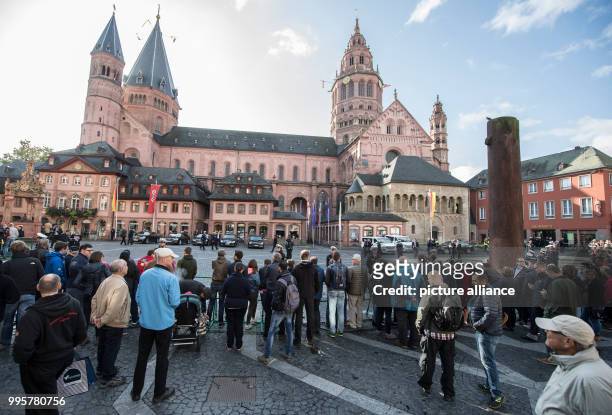 Spectators and visitors wait for the German chancellor Merkel and the constitutional bodies behind police crowd barriers in front of the cathedral in...