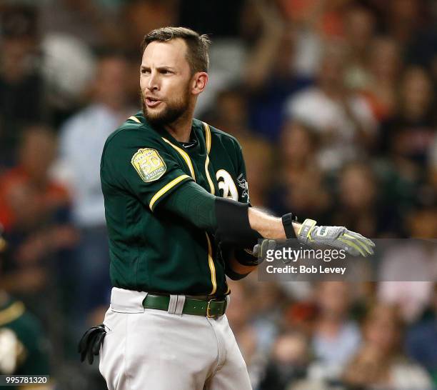 Jed Lowrie of the Oakland Athletics has words with home plate umpire David Rackley after he was called out on strikes in the sixth inning against the...