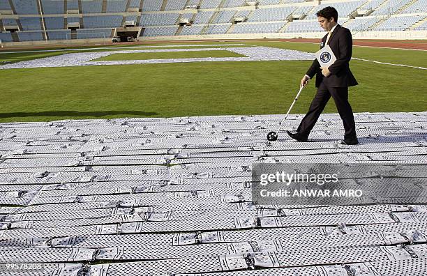 Guiness World Records representative Jack Brockbank measures the length of the world's largest keffiyeh, the traditional black-and-white chequerred...