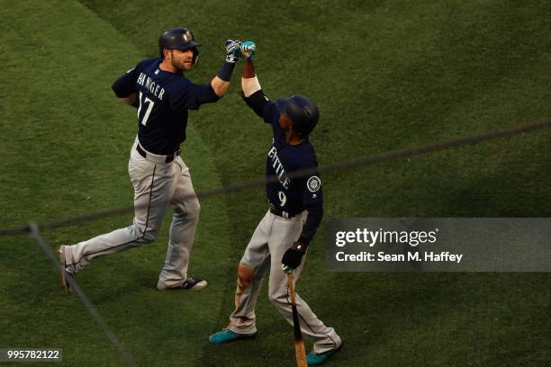 Mitch Haniger is congratulated by Dee Gordon of the Seattle Mariners after hitting a solo homerun during the first inning of a game against the Los...
