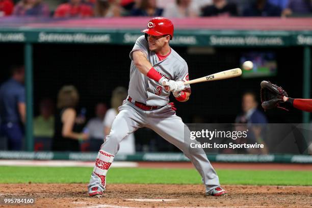 The ball deflects off the hand of Cincinnati Reds second baseman Scooter Gennett as he was hit by a pitch during the ninth inning of the Major League...