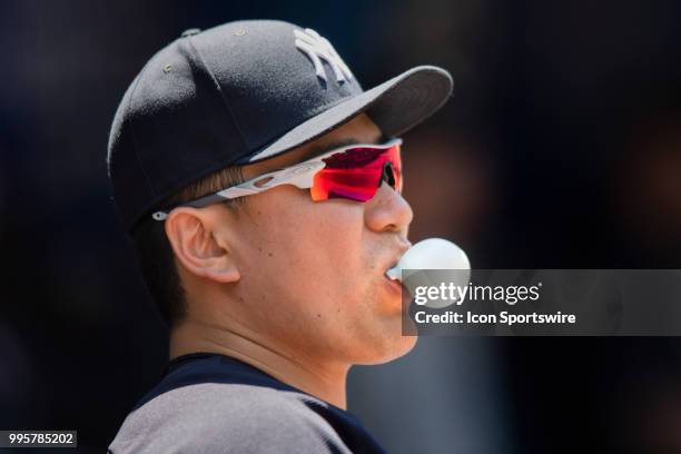 New York Yankees Starting pitcher Masahiro Tanaka watches the game as he blows bubbles in the Yankees Dugout during the MLB game between the New York...