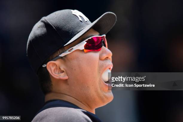 New York Yankees Starting pitcher Masahiro Tanaka watches the game as he blows bubbles in the Yankees Dugout during the MLB game between the New York...