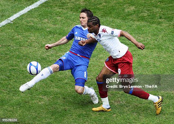 Frank Lampard of Chelsea plays the ball under pressure from Frederic Piquionne of Portsmouth during the FA Cup sponsored by E.ON Final match between...
