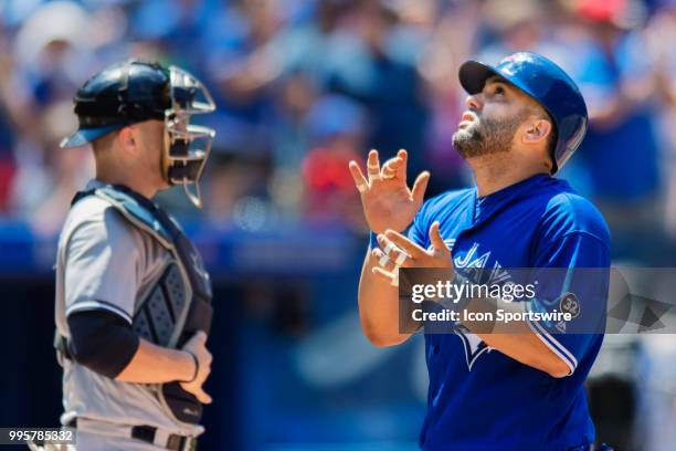 Toronto Blue Jays Designated hitter Kendrys Morales motions upward at home plate after scoring the Jays only run in the MLB game between the New York...