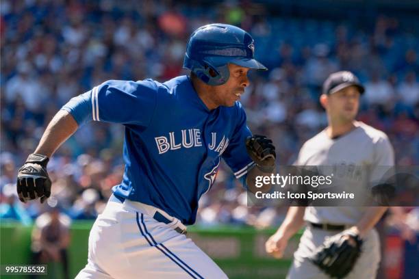 Toronto Blue Jays Outfield Curtis Granderson sprints to first as New York Yankees Pitcher David Robertson watches the inbound throw during the MLB...