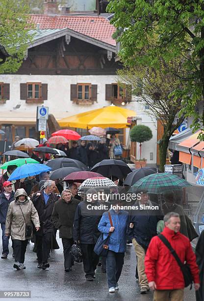 People shelter from the rain under umbrellas as they arrive for the premiere of the Passionplay 2010 on May 15, 2010 in Oberammergau, Germany. The...