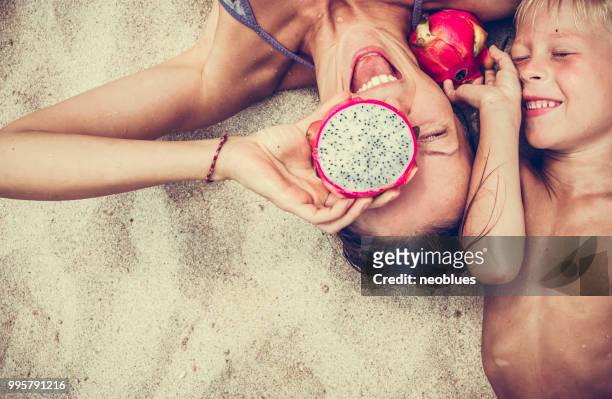 glückliche frau und junge setzt drachenfrucht als gläser. - boy thailand stock-fotos und bilder