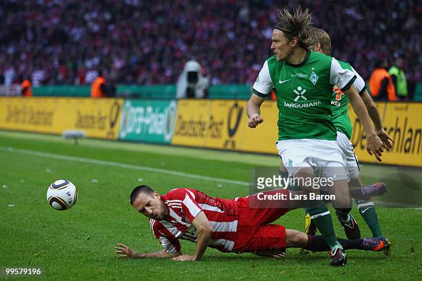 Franck Ribery of Bayern is tackled by Clemens Fritz of Bremen during the DFB Cup final match between SV Werder Bremen and FC Bayern Muenchen at...