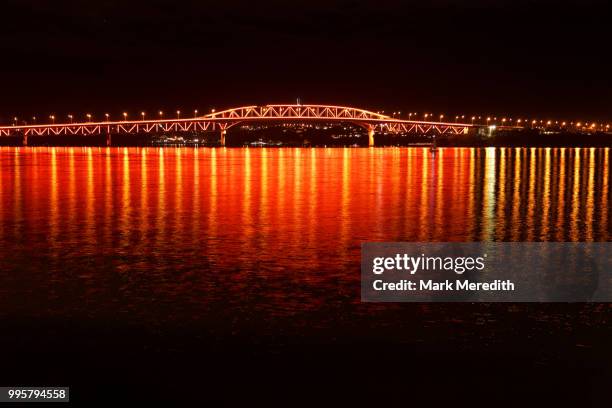 reflections and lights on auckland's harbour bridge celebrating matariki, the beginning of the maori new year - matariki stockfoto's en -beelden