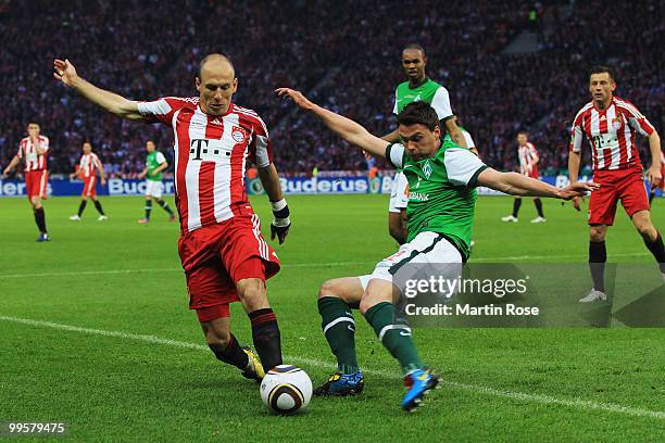 Sebastian Boenisch of Bremen challenges Arjen Robben of Bayern during the DFB Cup final match between SV Werder Bremen and FC Bayern Muenchen at...