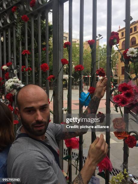 Javier Mendez Sanz, a 33-year-old factory worker attaches a carnation to the gate of the Ramon Llull school in Barcelona, Spain, 3 October 2017....