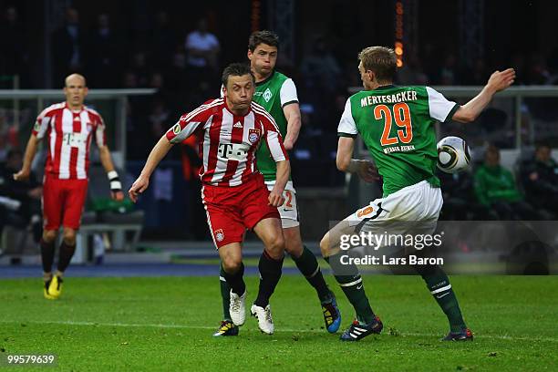 Per Mertesacker of Bremen plays hand while Ivica Olic of Bayern looks on during the DFB Cup final match between SV Werder Bremen and FC Bayern...