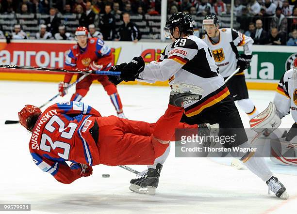 Alexander Barta of Germany battles for the puck with Maxim Sushinsky of Russia during the IIHF World Championship qualification round match between...