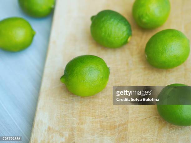 whole limes closeup on wooden cutting board - greengage stock pictures, royalty-free photos & images