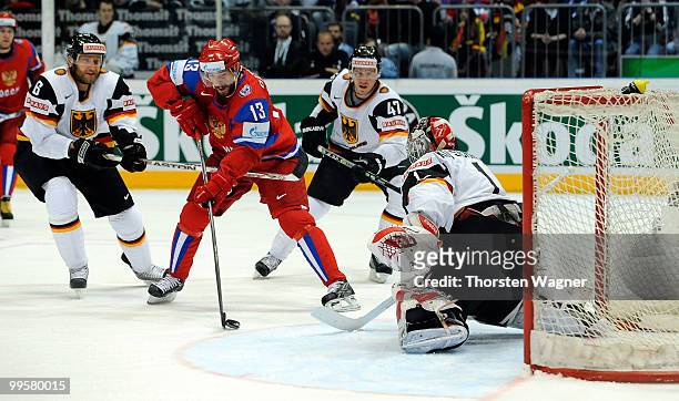 Sven Butenschoen , Dimitri Kotschnew and Christoph Ullmann of Germany battles for the puck with a player of Russia during the IIHF World Championship...