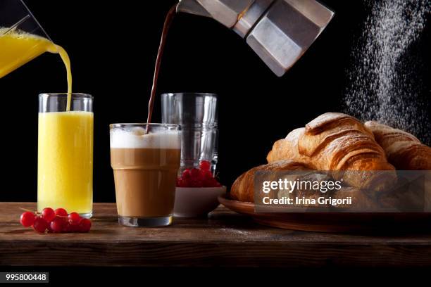 table breakfast. fresh hot croissants, pouring ora - foodora stock-fotos und bilder