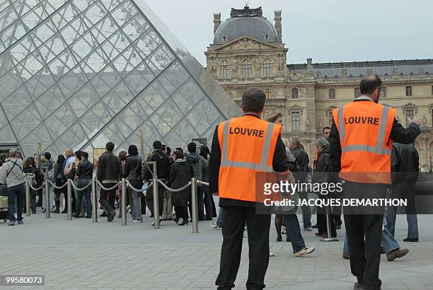 Security guards conduct people to queue at the entrance of the Louvre Museum during the 6th edition of the "Nuit des musees" yearly event on May 15,...