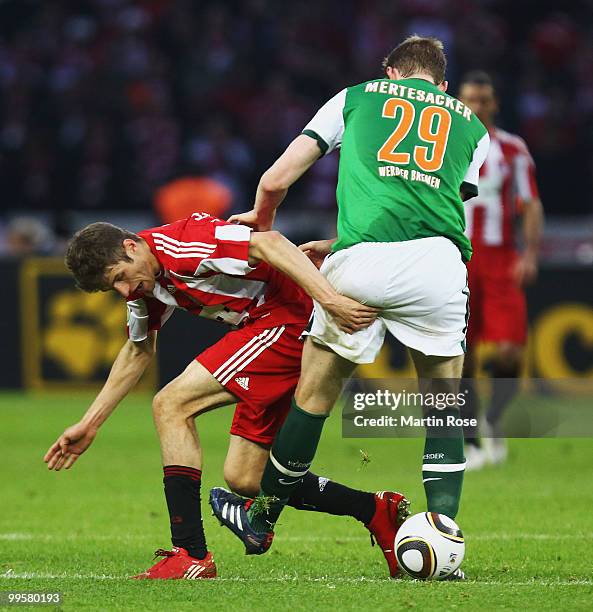 Per Mertesacker of Bremen and Thomas Mueller of Bayern battle for the ball during the DFB Cup final match between SV Werder Bremen and FC Bayern...