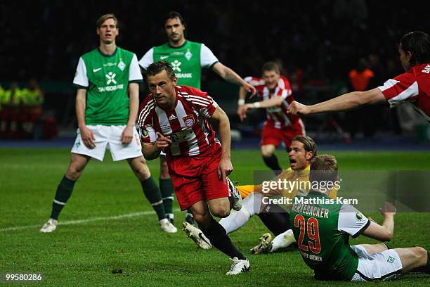 Ivica Olic of Bayern celebrates after scoring his team's second goal while player of Bremen look dejected during the DFB Cup final match between SV...