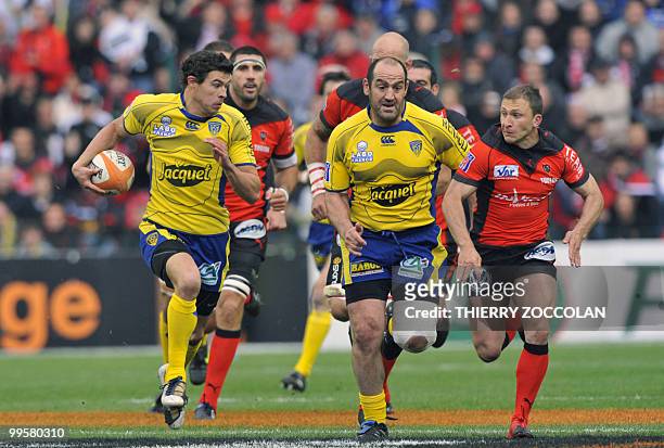 Clermont's French fullback Anthony Floch runs with the ball next to Mario Ledesma and Toulon scrum half Pierre Mignoni during the French Top 14 semi...