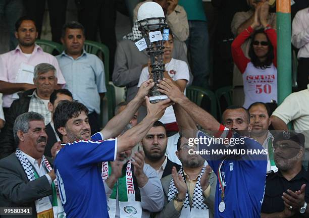 Palestinian Rafah youth club players representing "France" hold up the trophy of a mock World Cup match they won in Gaza city on May 15, 2010....