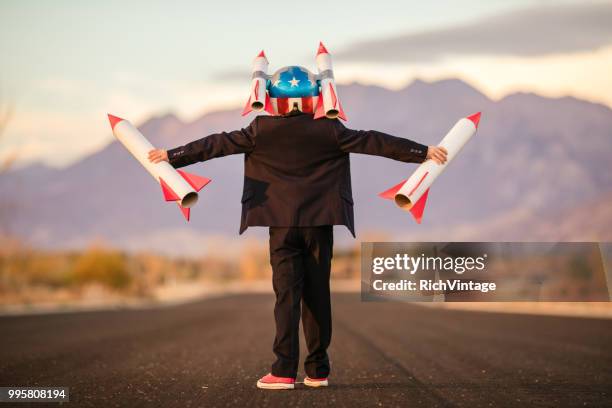 young business boy in helmet holding rockets - adult imitation stock pictures, royalty-free photos & images