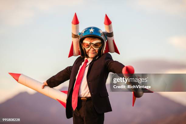 young business boy in helmet holding rockets - adult imitation stock pictures, royalty-free photos & images