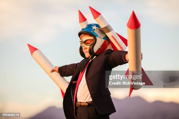 giovane uomo d'affari in helmet holding rockets - festa per il lancio pubblicitario foto e immagini stock