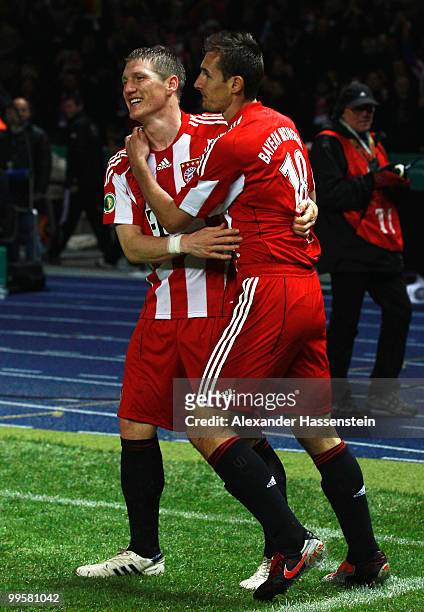 Bastian Schweinsteiger of Bayern celebrates after scoring his team's fourth goal with team mate Miroslav Klose during the DFB Cup final match between...
