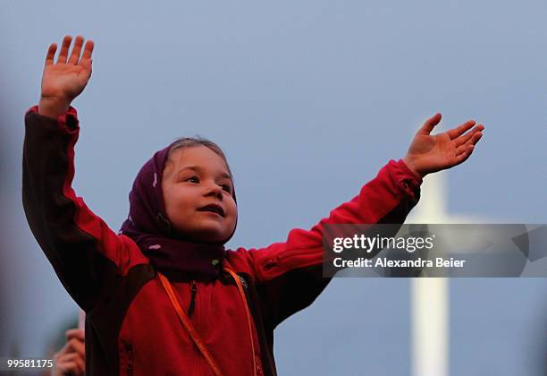 Young girl waves before a concert of German singer Nena at the fourth day of the 2nd ecumenical Kirchentag on May 15, 2010 in Munich, Germany.