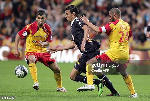 Bordeaux' striker Marouane Chamakh runs with the ball between Lens' players Adil Hermach and Eric Chelle during the French L1 football match Lens vs....