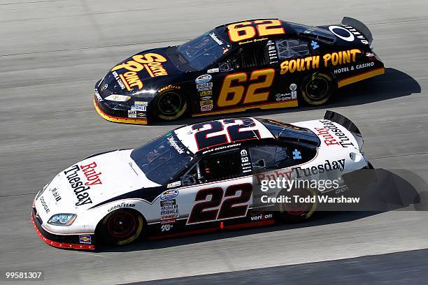 Brad Keselowski, driver of the Ruby Tuesday Dodge, and Brendan Gaughan, driver of the South Point Casino & Hotel Toyota, race side by side during the...