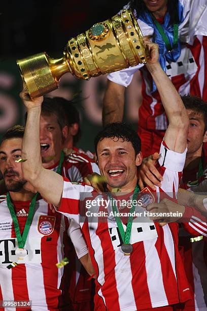 Mark van Bommel of Bayern Muenchen lifts the DFB Cup trophy following his team's victory at the end of the DFB Cup final match between SV Werder...