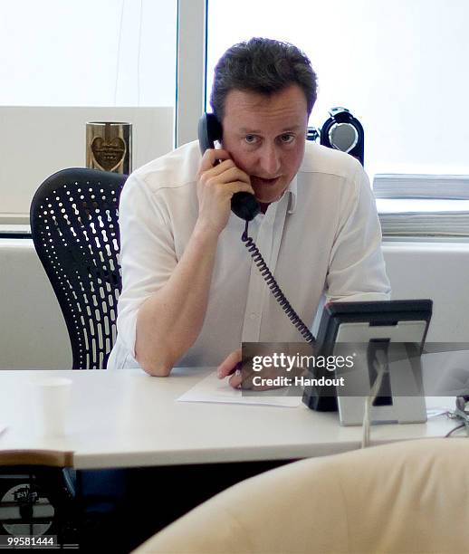 In this handout image provided by the Conservative Party, Leader of the Conservative Party David Cameron talks to the Liberal Democrat leader Nick...