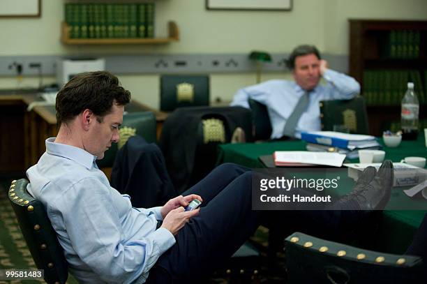 In this handout image provided by the Conservative Party, George Osborne checks his Blackberry in David Cameron's office in Portcullis House in the...