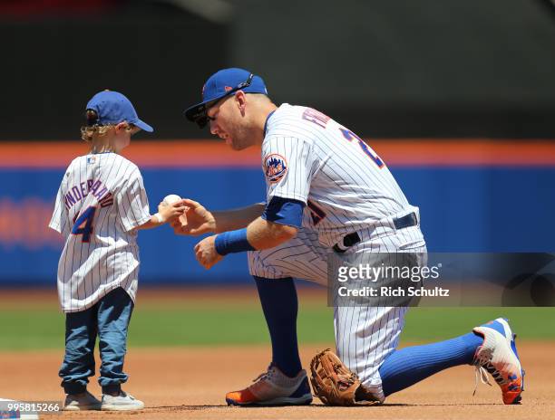 Todd Frazier of the New York Mets gives a ball to a child before a game against the Tampa Bay Rays at Citi Field on July 8, 2018 in the Flushing...