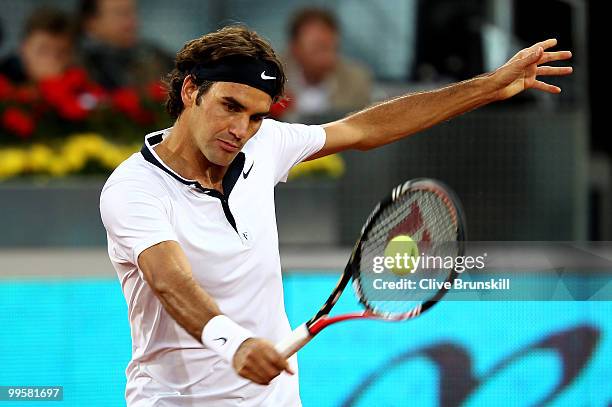 Roger Federer of Switzerland plays a backhand against David Ferrer of Spain in their semi final match during the Mutua Madrilena Madrid Open tennis...