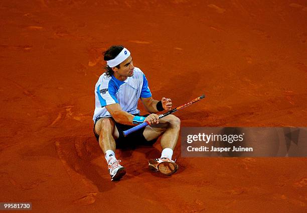 David Ferrer of Spain sits on court in his semi-final match against Roger Federer of Switzerland during the Mutua Madrilena Madrid Open tennis...