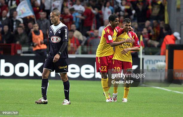 Lens' Tunisian forward Issam Jemaa is congratulated by team-mate as Bordeaux' Wendel walks during the French L1 football match Lens vs. Bordeaux on...