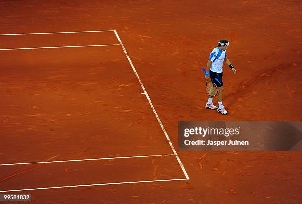 David Ferrer of Spain trudges on court in his semi-final match against Roger Federer of Switzerland during the Mutua Madrilena Madrid Open tennis...