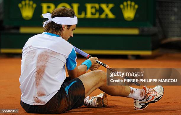 Spanish David Ferrer falls during a semi-final match of the Madrid Masters against Swiss Roger Federer on May 15, 2010 at the Caja Magic sports...